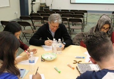 IDEO co-founder, Dennis Boyle, sits with students as they generate ideas