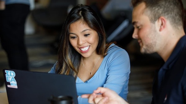 Two students working together on a screen